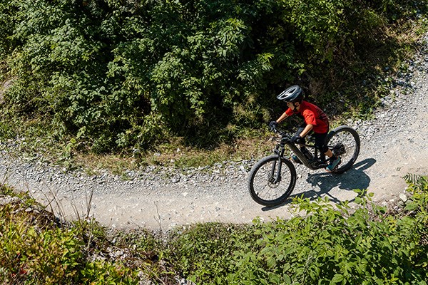 Kids riding specialized bike around a sweeping turn wearing a helmet